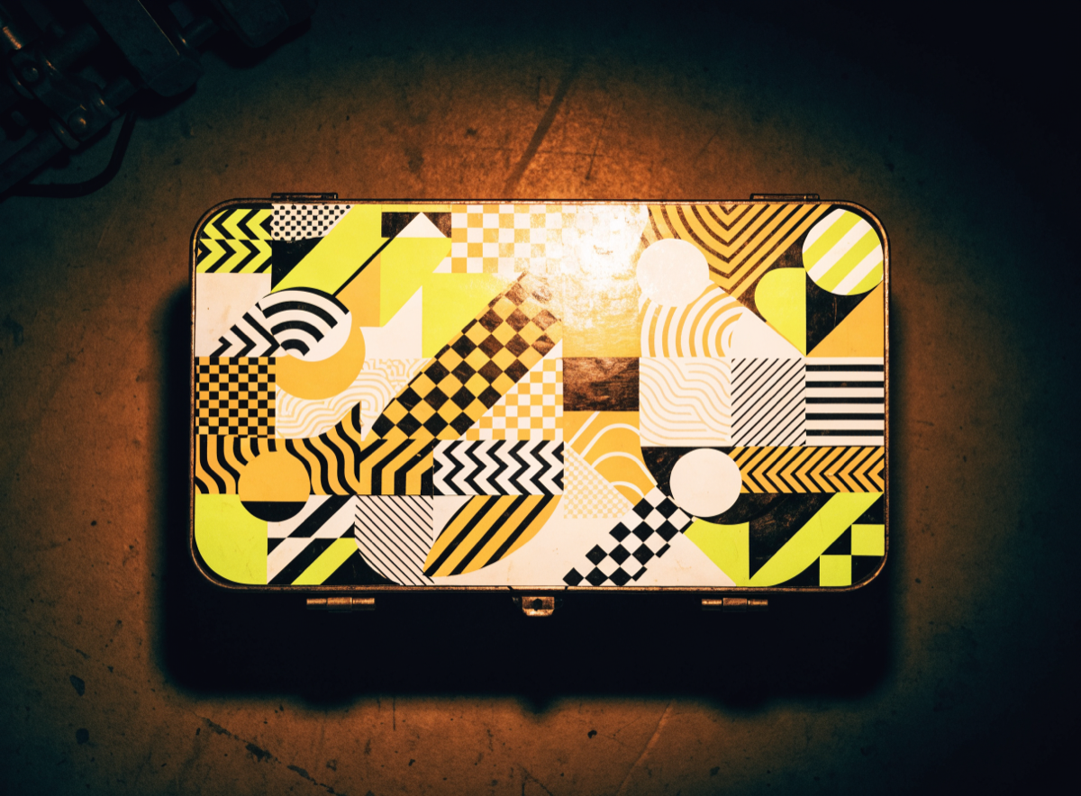 Toolbox lid densely covered in abstract die-cut vinyl stickers